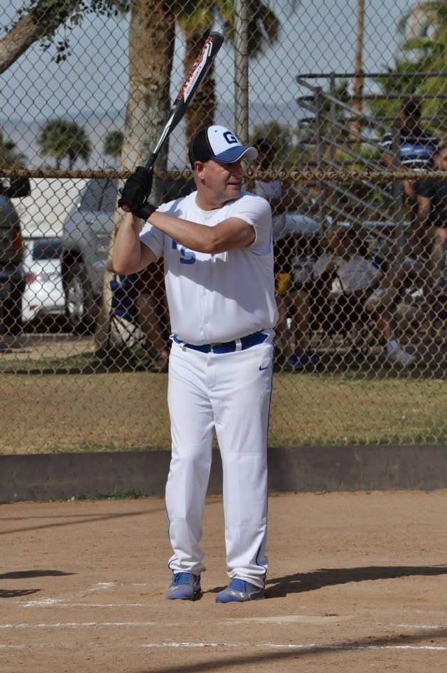 Baseball player in white uniform holding a bat in batting stance at the plate.