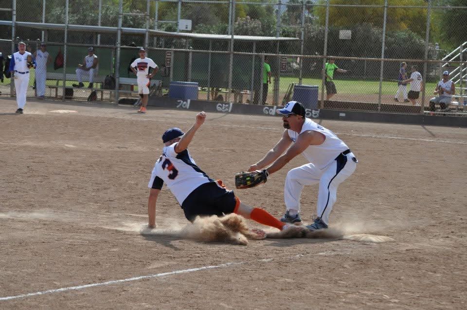 Baseball player slides into base as the fielder tags him during a game.