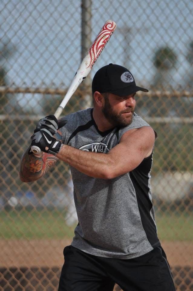 Baseball player in gray and black uniform preparing to swing a bat on a field.