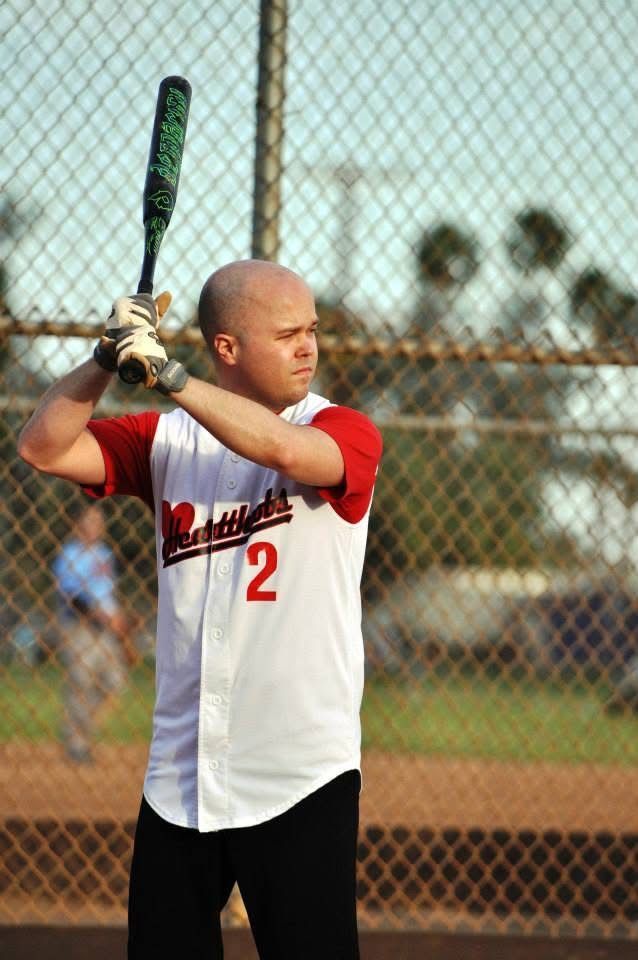 Baseball player in white and red uniform ready to bat on a field