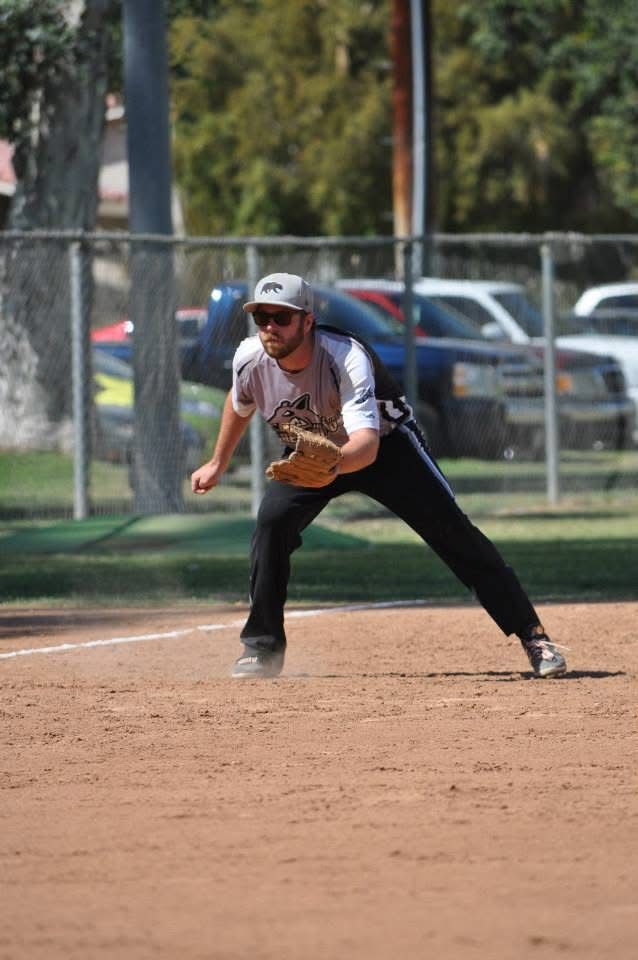 Baseball player in gray uniform fielding a ground ball on a dirt infield