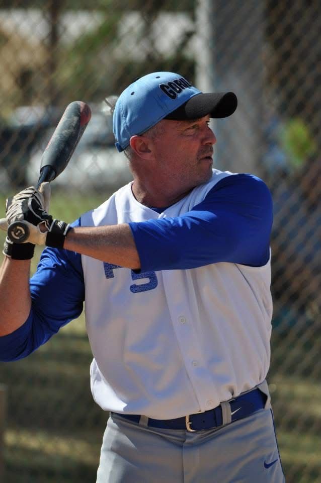 Baseball player in blue and white uniform preparing to swing a bat outdoors