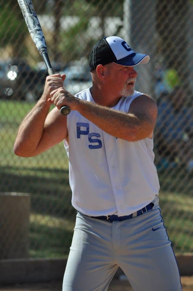 Baseball player in white and blue uniform at bat on a sunny field