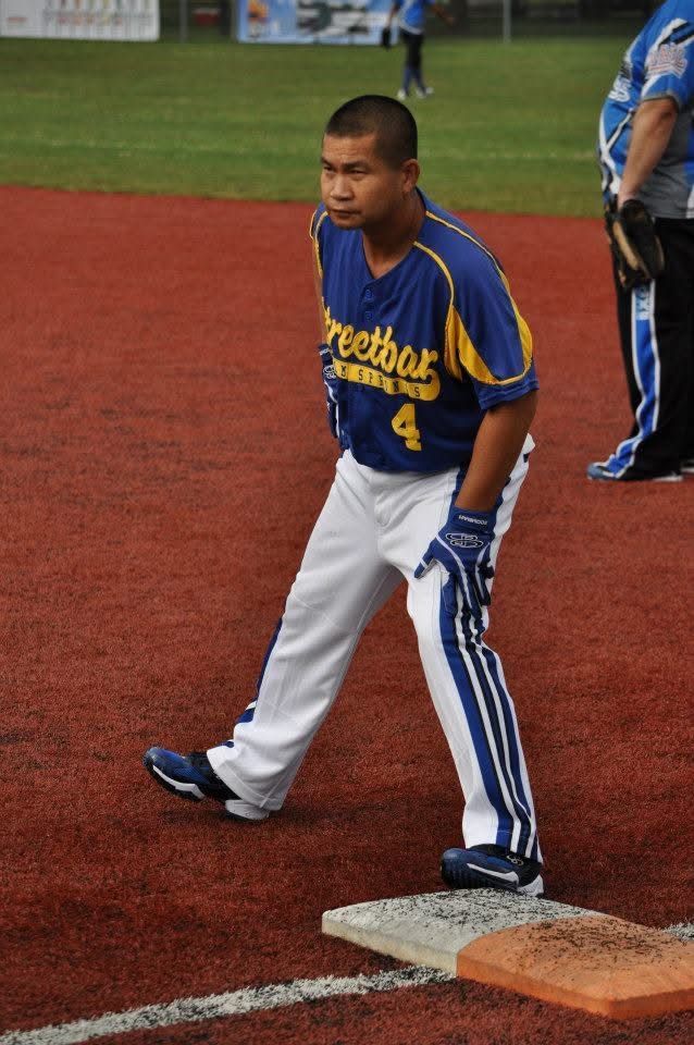 Baseball player in blue and white uniform standing on the base line near a base on the field.