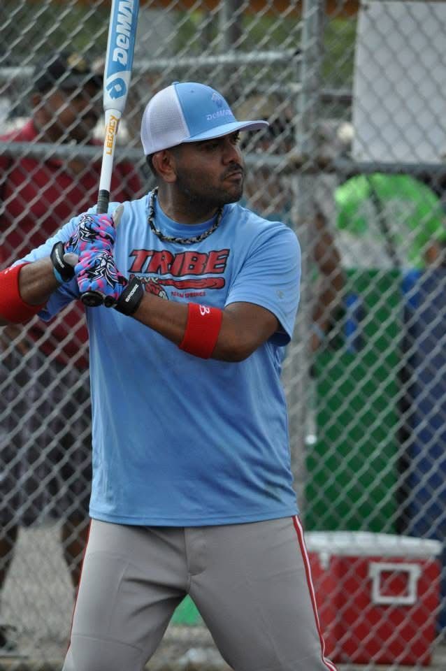 Baseball batter in blue jersey and gray pants holding a bat at the plate, ready to swing