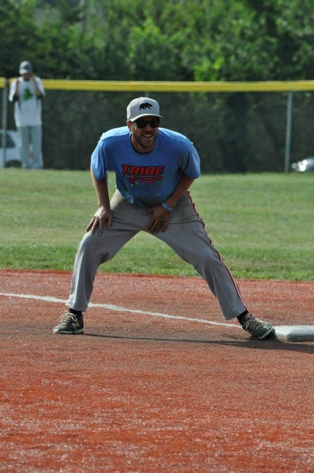 Baseball player in blue jersey crouches ready on the infield near first base