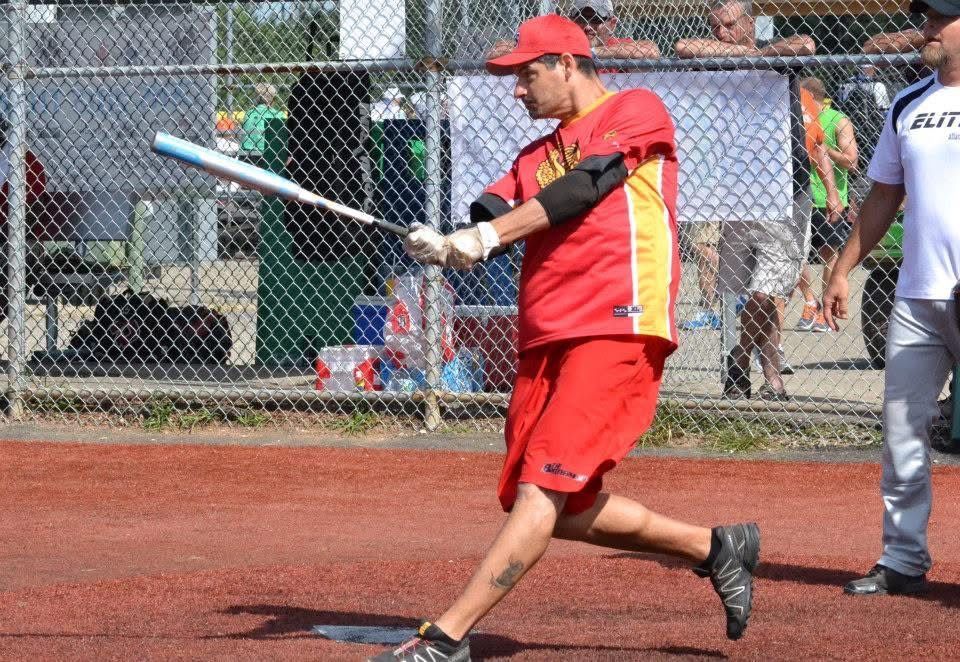 Baseball player in red uniform swinging a bat on a field