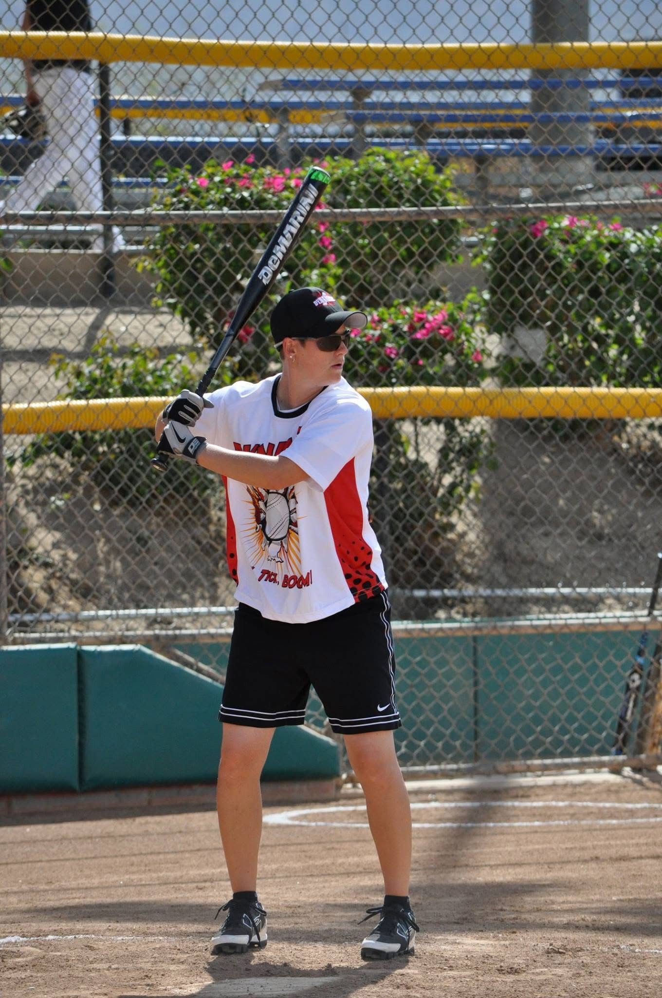 Baseball player in white and black uniform preparing to swing on a field.