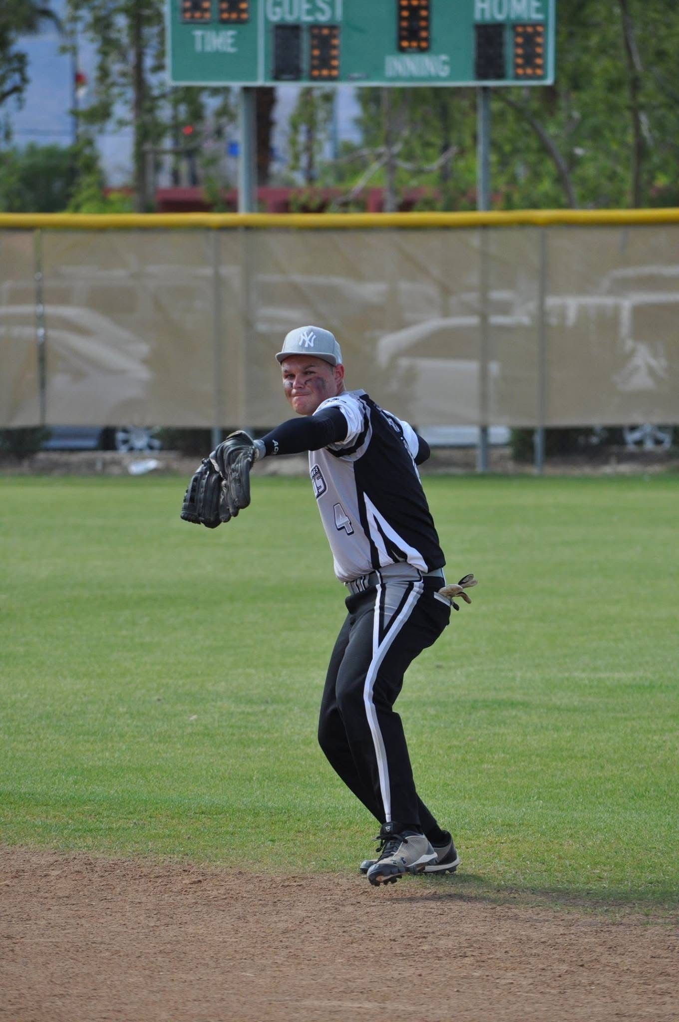 Baseball player in black and white uniform preparing to throw a ball on a field