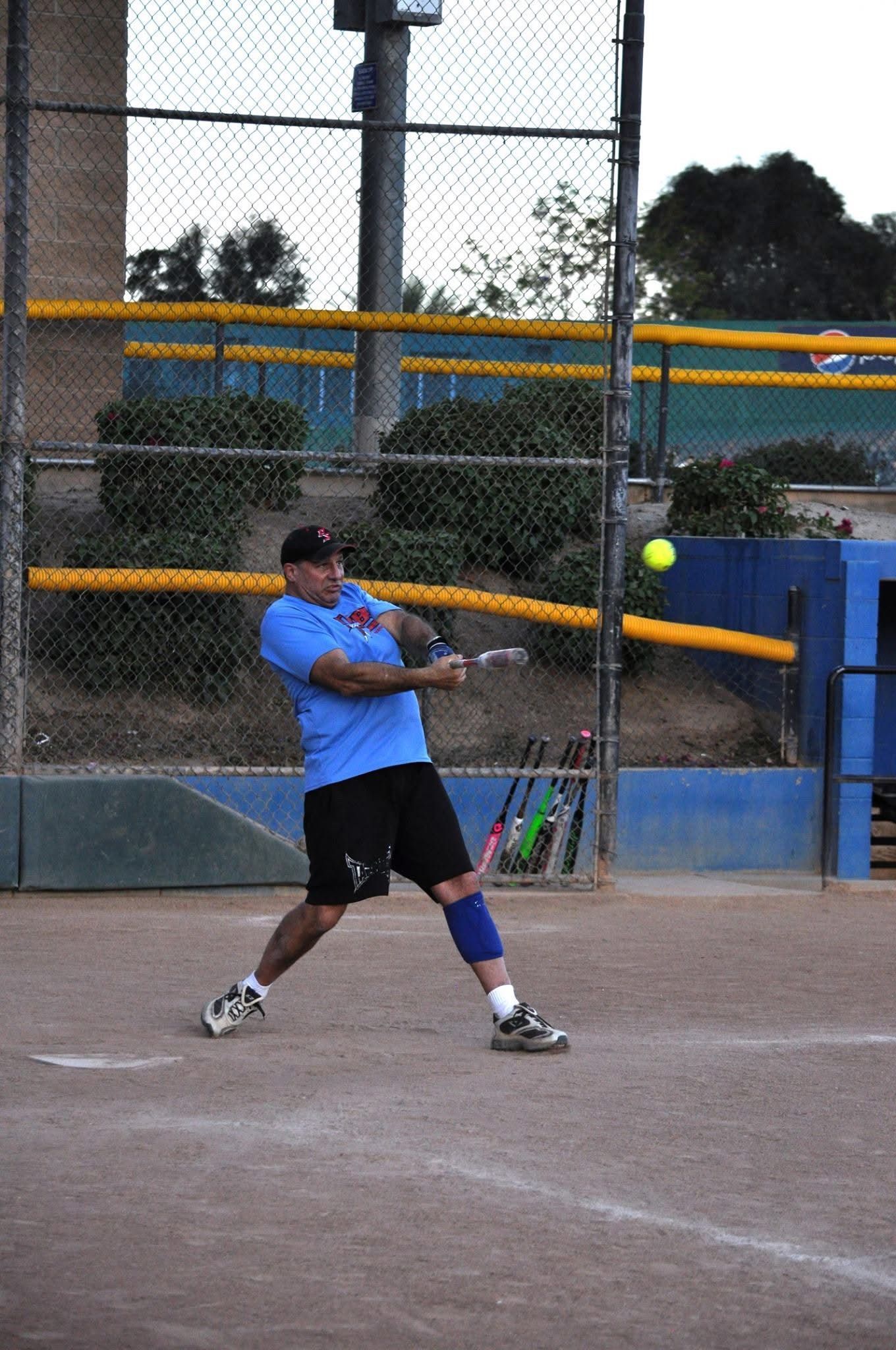 Tennis player in blue shirt swings at a ball on an outdoor court.