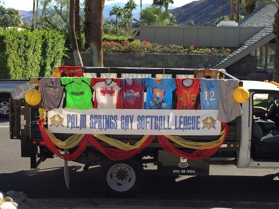 Decorated truck float displaying colorful sports jerseys and a banner reading “All Stars Day Softball League”