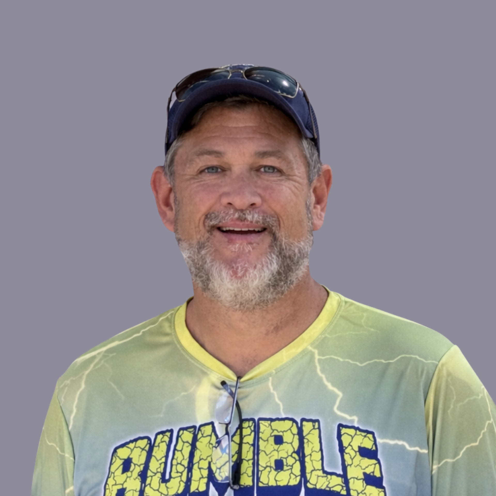 Smiling man in a blue cap wearing a yellow-and-blue Rumble jersey with number 11