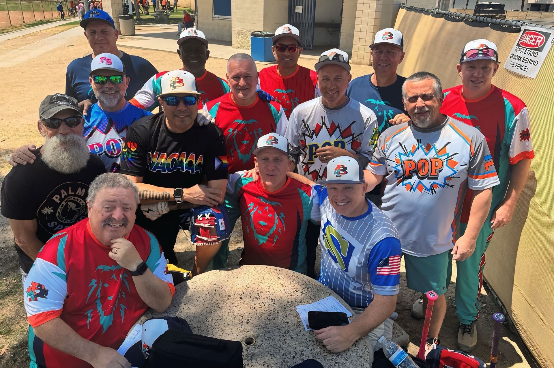 Group of people in colorful cycling jerseys posing outdoors with bicycles on a sunny day
