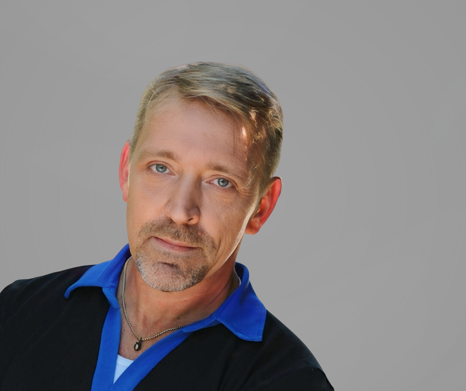 Portrait of a man in a black shirt with a bright blue collar against a gray background