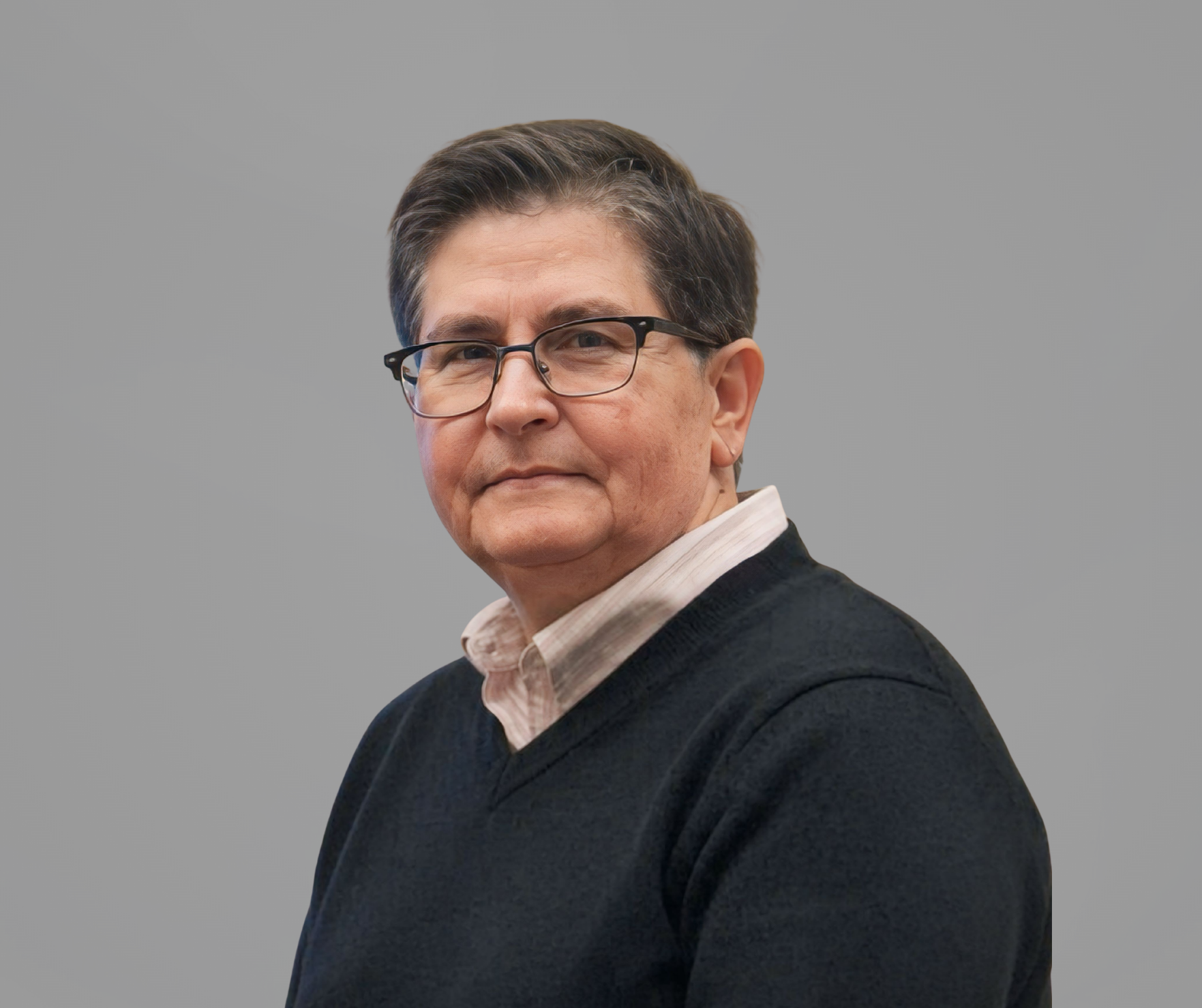 Portrait of a person in glasses wearing a dark sweater against a gray background