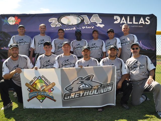 Baseball team posing outdoors in gray jerseys in front of a Dallas banner with a team logo banner.