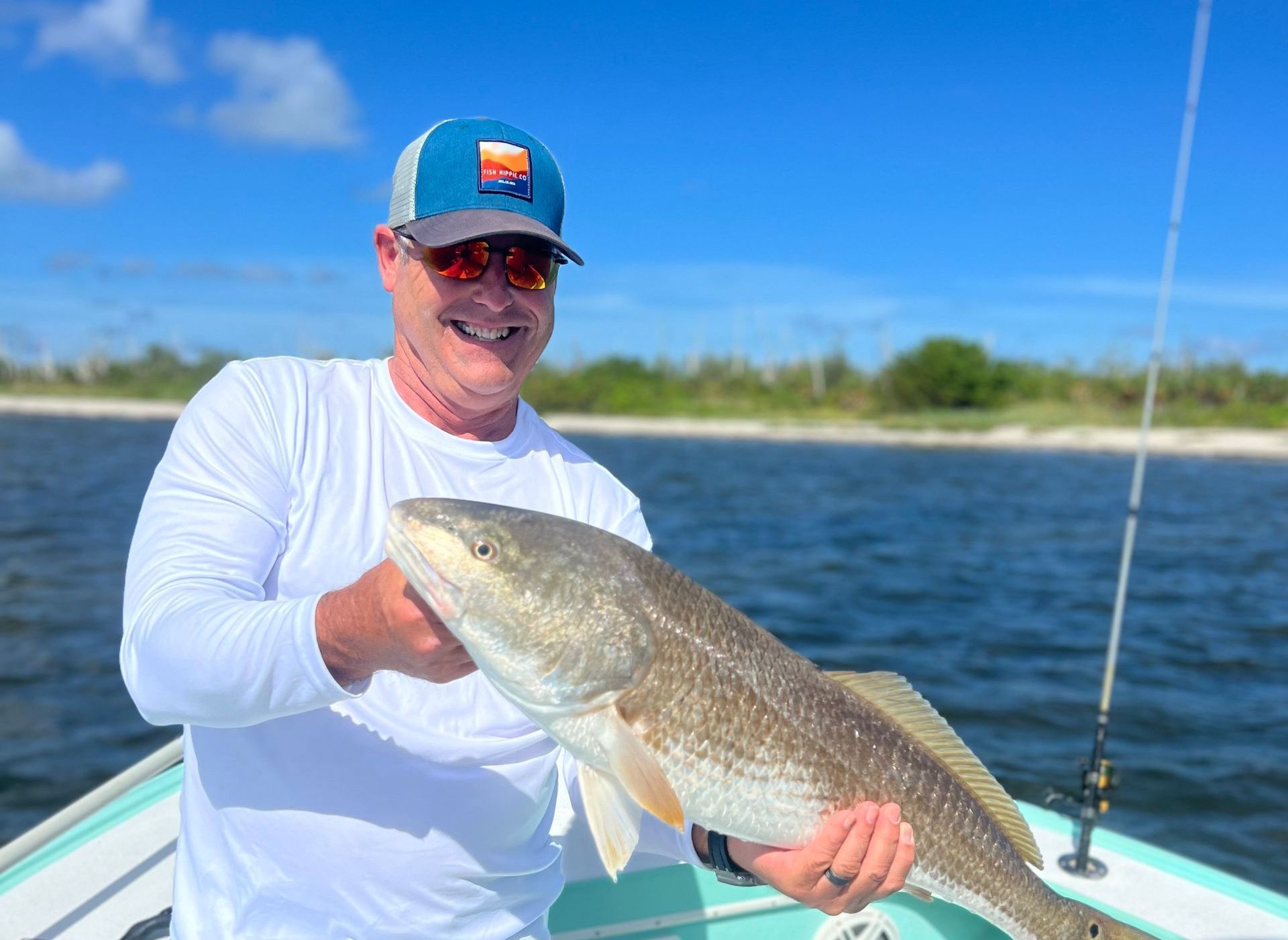 A man is holding a large fish on the side of a boat.