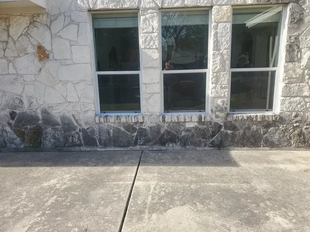 There are three windows on the side of a building.