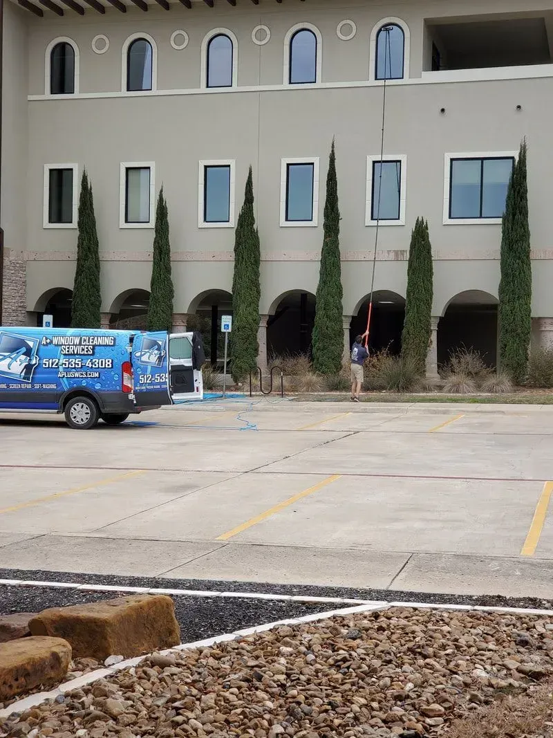 A van is parked in a parking lot in front of a building.