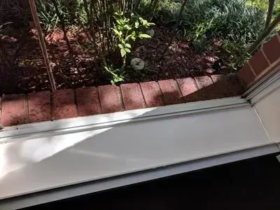 A white window sill with a brick wall in the background.