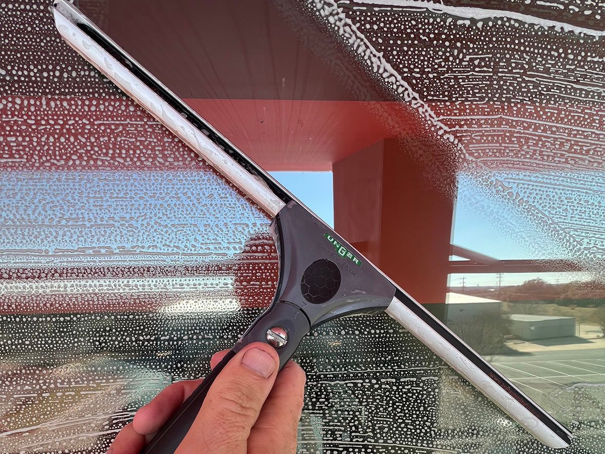 Squeegee taking water off of a window 