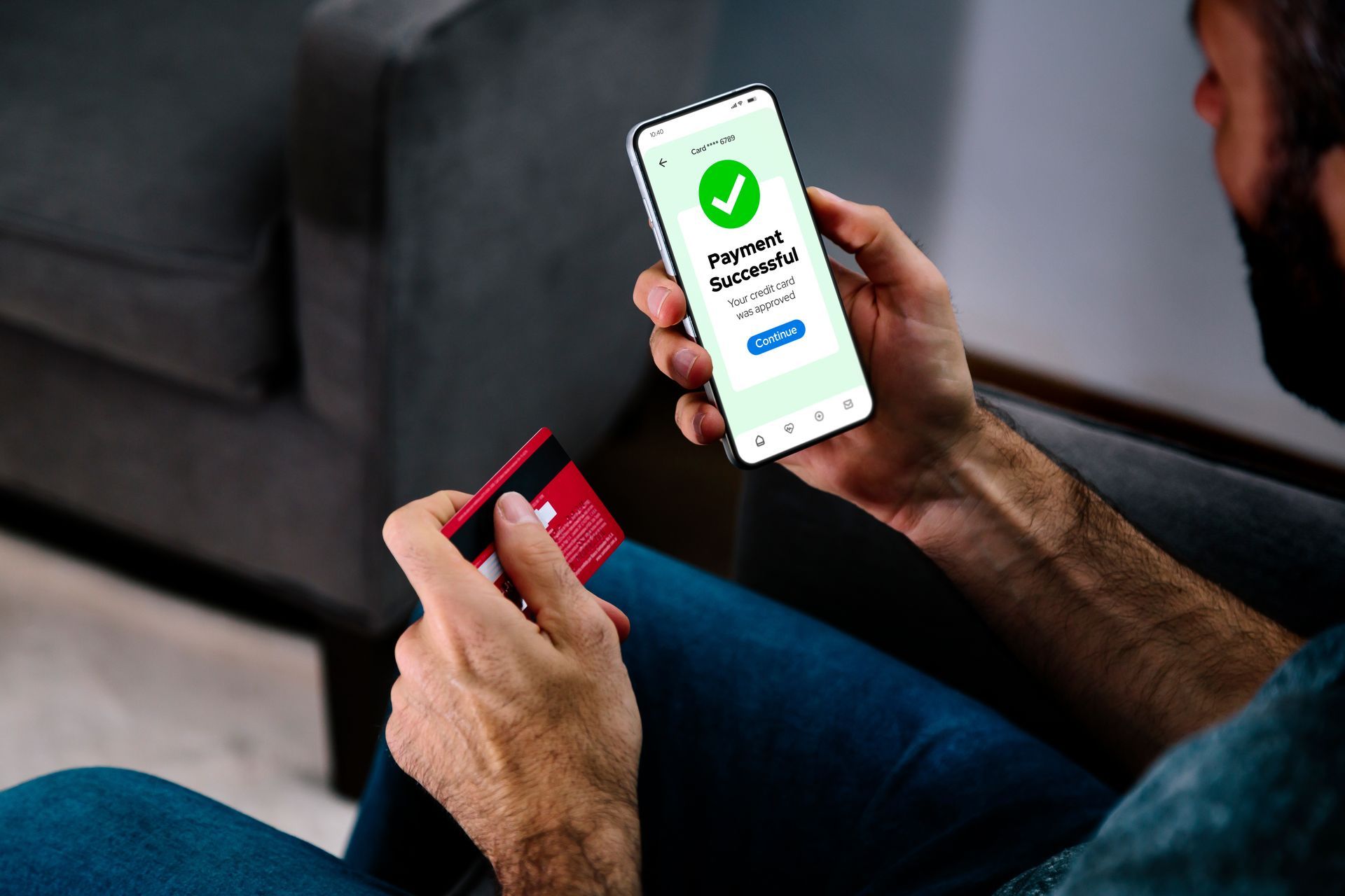 Person holding a credit card and smartphone displaying a successful payment confirmation. Person holding a credit card and smartphone displaying a successful payment confirmation.