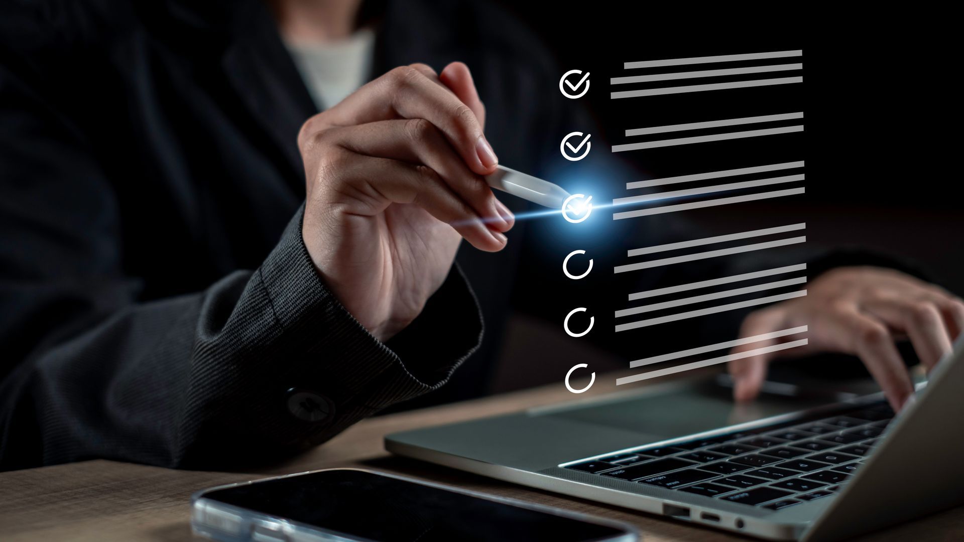Person in dark suit marking a digital checklist on a laptop screen with a stylus. Person in dark suit marking a digital checklist on a laptop screen with a stylus.