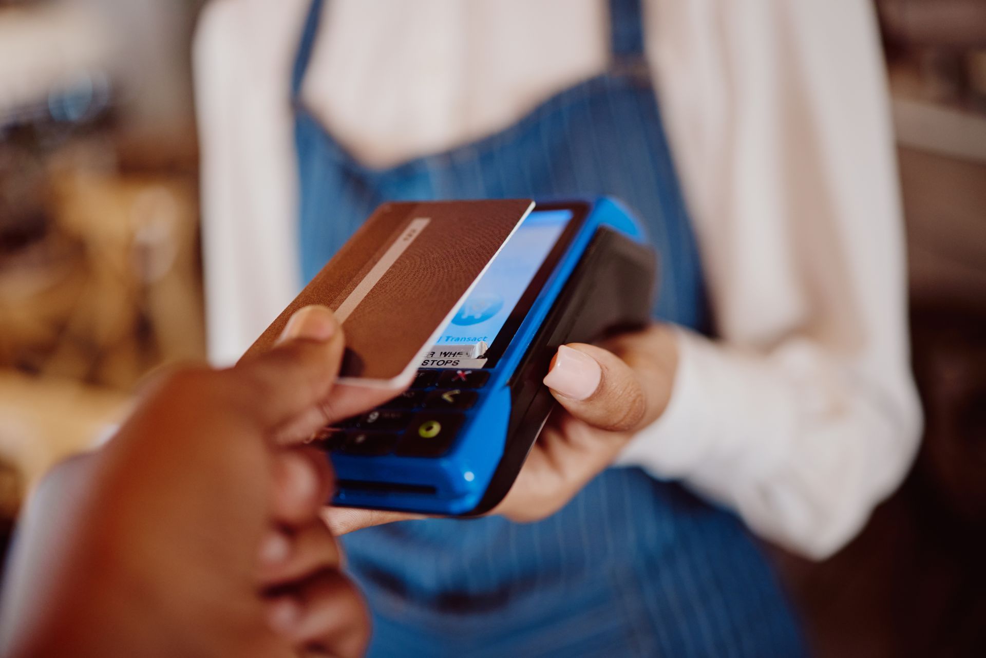 Person using a contactless payment card at a point-of-sale terminal. Person using a contactless payment card at a point-of-sale terminal.
