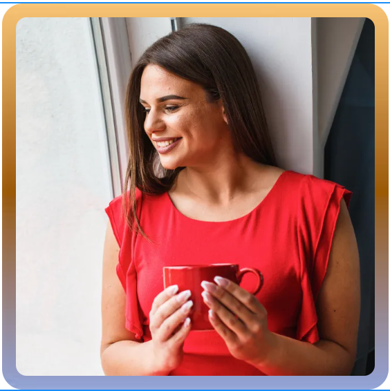 a woman in a red shirt is holding a red cup of coffee