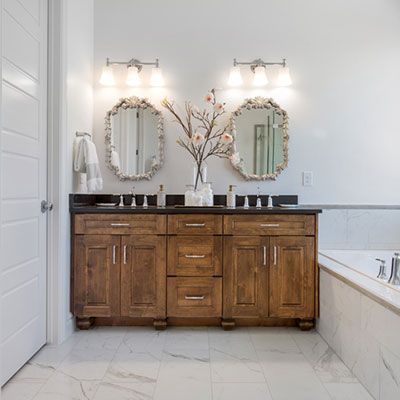 Gorgeous bathroom with dark cabinetry amidst white surroundings