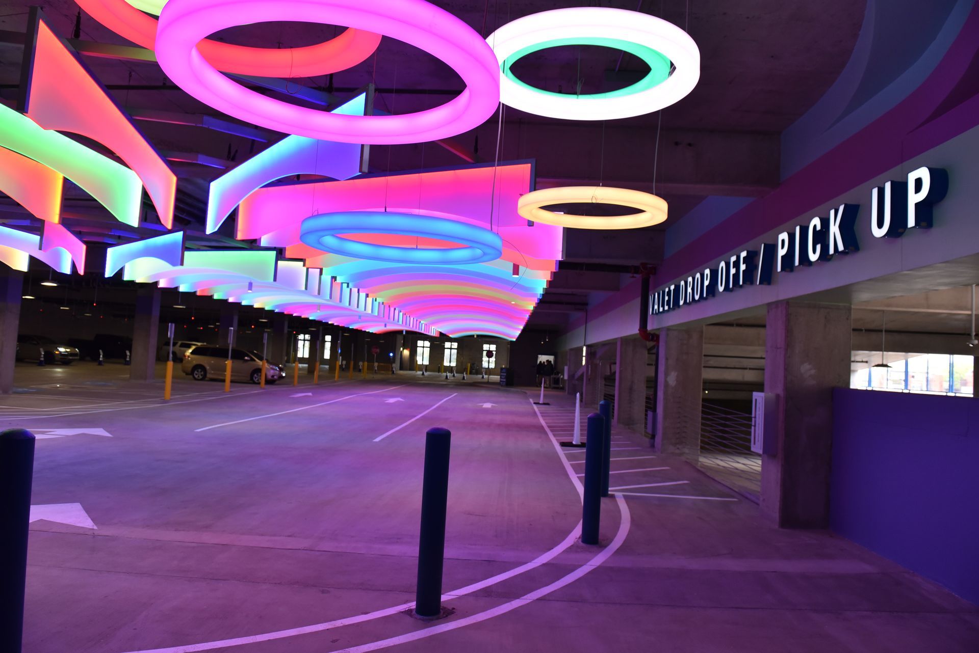 A colorful, neon-lit parking garage with a 