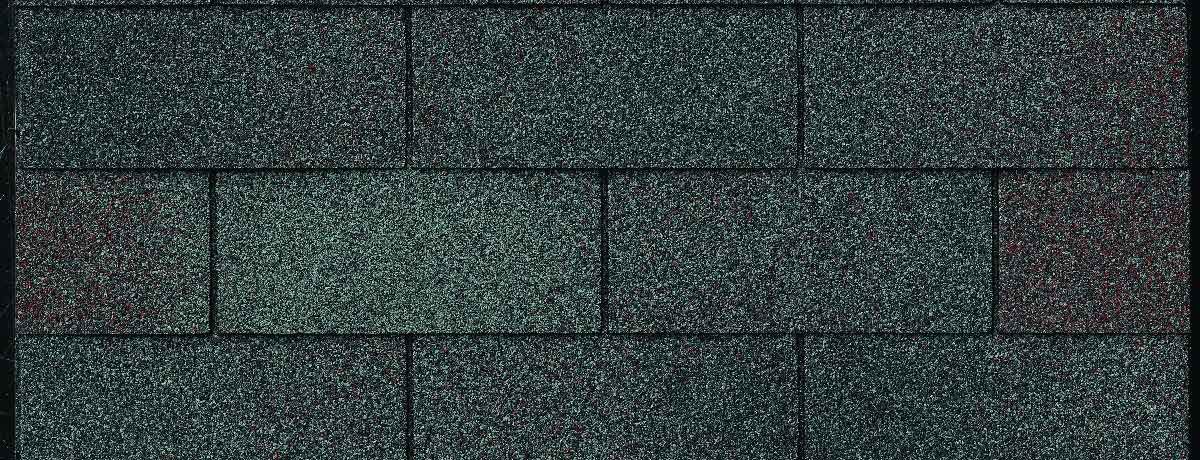 Close-up of a section of dark green asphalt roof shingles.