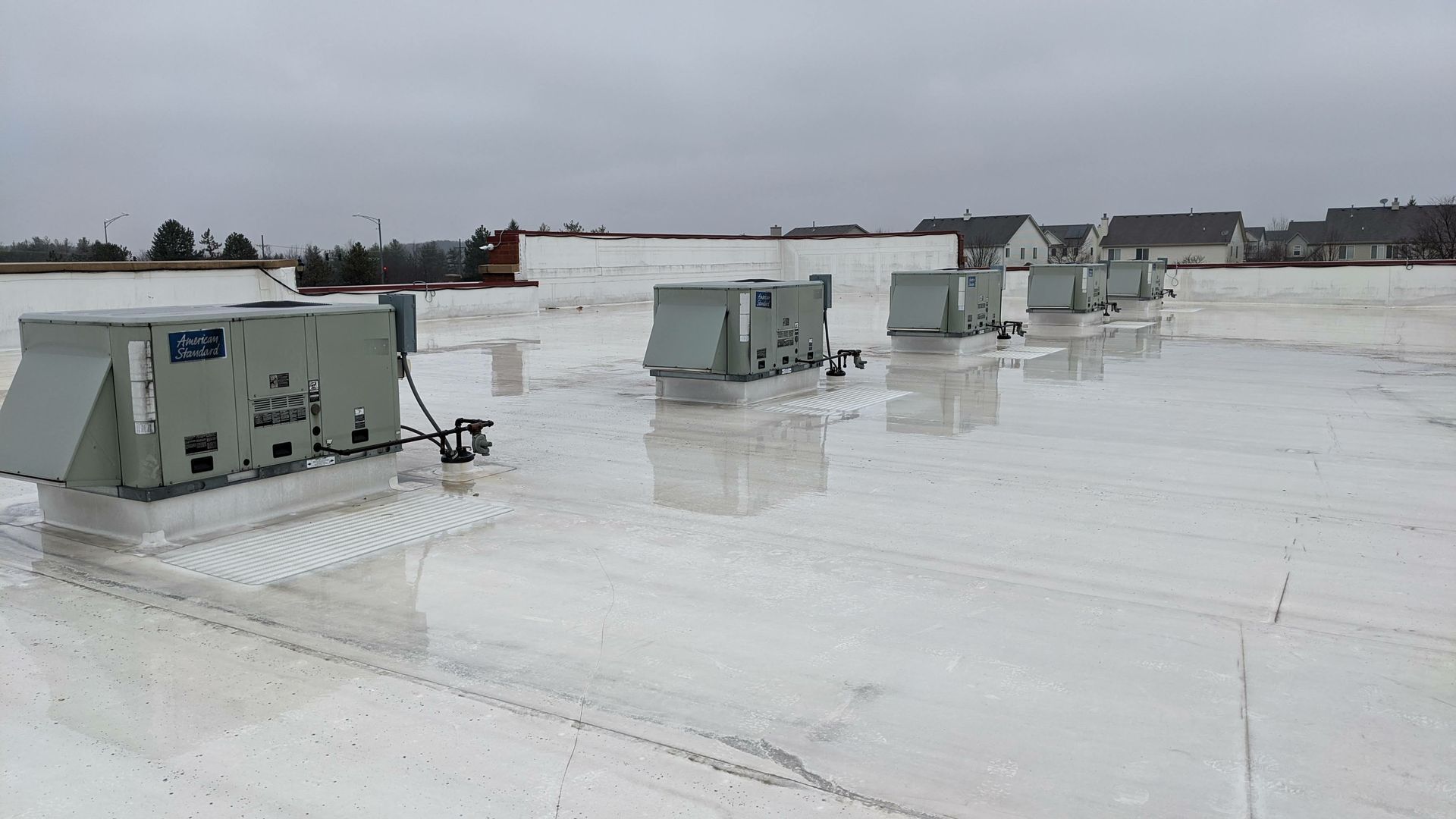 Expert crew performing a commercial roofing installation on a large-scale industrial metal roof.