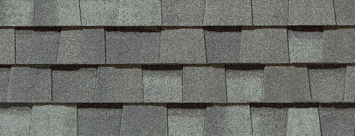 Gray asphalt roof shingles in an overlapping pattern.