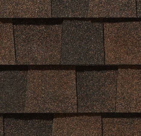 Close-up of brown asphalt roof shingles in a layered pattern.