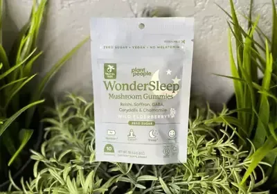 A bag of wondersleep mushroom gummies is sitting on top of a plant.