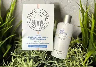 A bottle of lotion is sitting next to a card that says `` natural vegan made in usa ''.