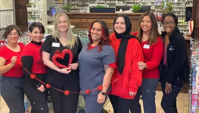 A group of women are posing for a picture in a pharmacy.