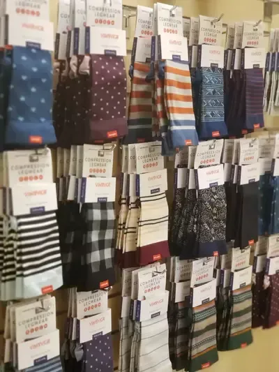 A row of socks hanging on a wall in a store