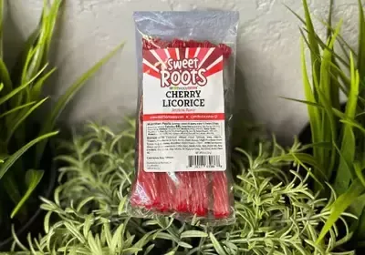 A bag of sweet roots cherry licorice is sitting on top of a plant.
