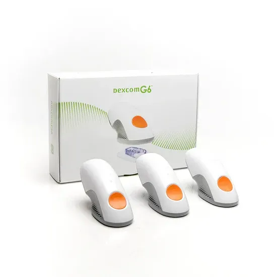 Box of Dexcom G6 CGM sensors and three individual sensors, white and orange.