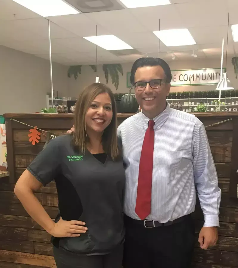 A man and a woman are posing for a picture in front of a sign that says community