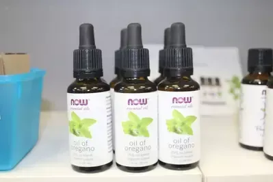 Three bottles of oil of oregano are sitting on a table.