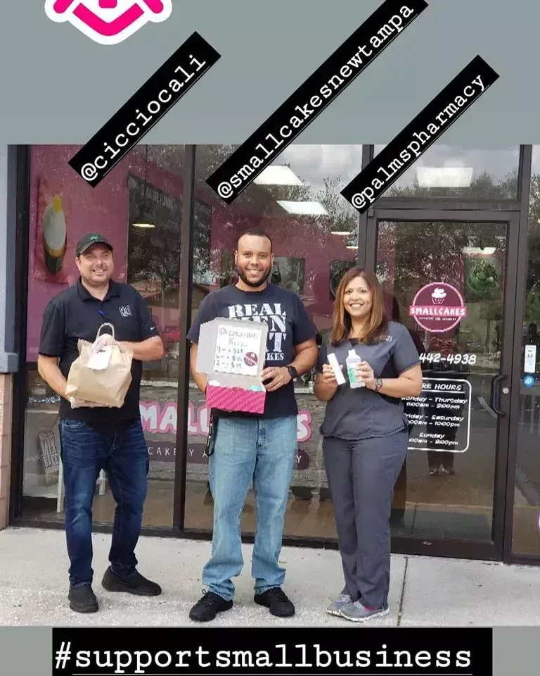 A group of people standing in front of a small business