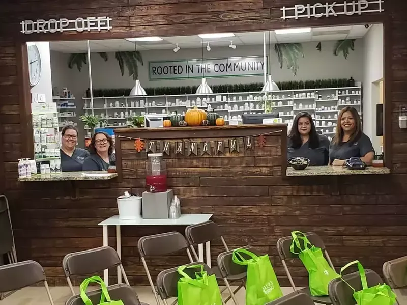 A group of people standing behind a counter in a pharmacy.