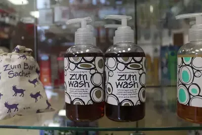 Two bottles of zum wash are sitting on a glass shelf.