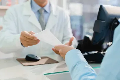 A pharmacist is giving a prescription to a patient in a pharmacy.