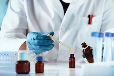 A scientist is using a pipette to pour liquid into a bottle.