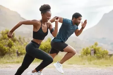 A man and a woman are running on a road.