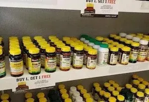 A shelf filled with lots of bottles of vitamins and supplements.